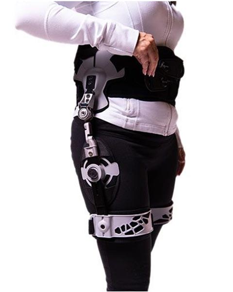 A woman wearing a hip brace after surgery with a device attached to it.