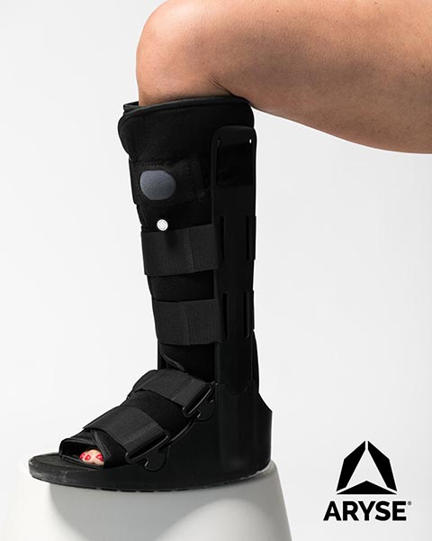 A person wearing a knee brace on a stool.